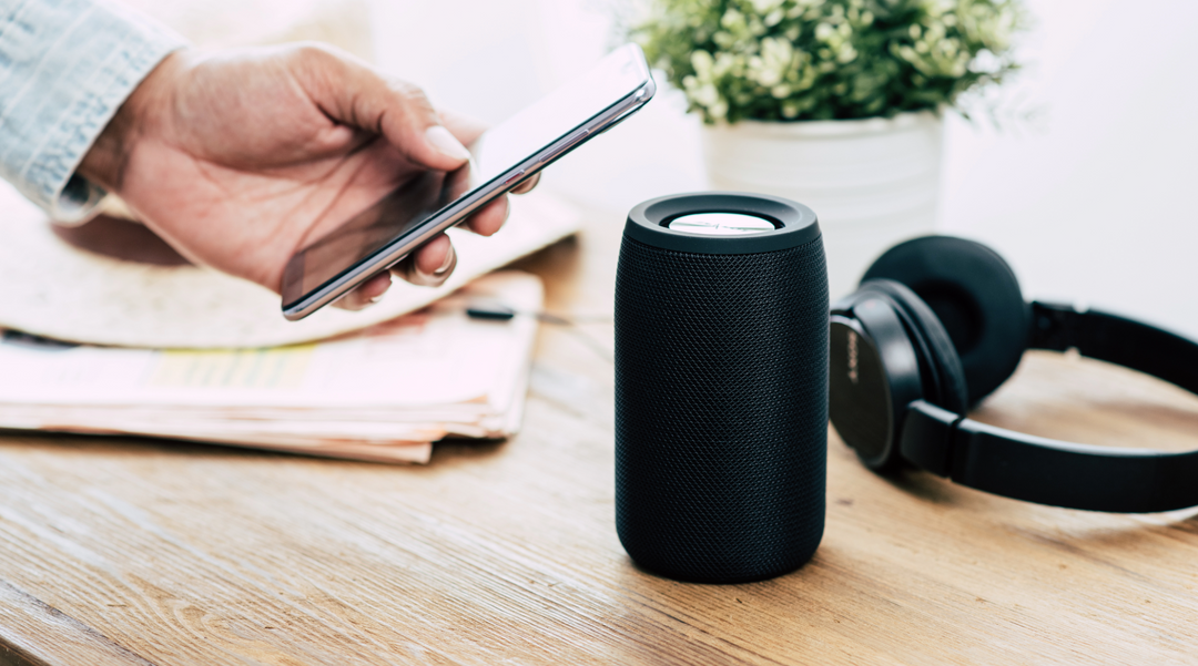 Blue speaker and earphones on desk - bluetooth speaker - tech gifts