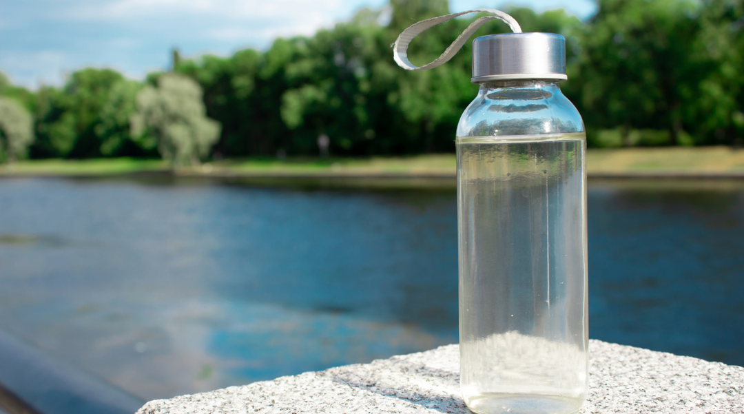 Glass water bottle on ledge - glass bottle - glass water bottle